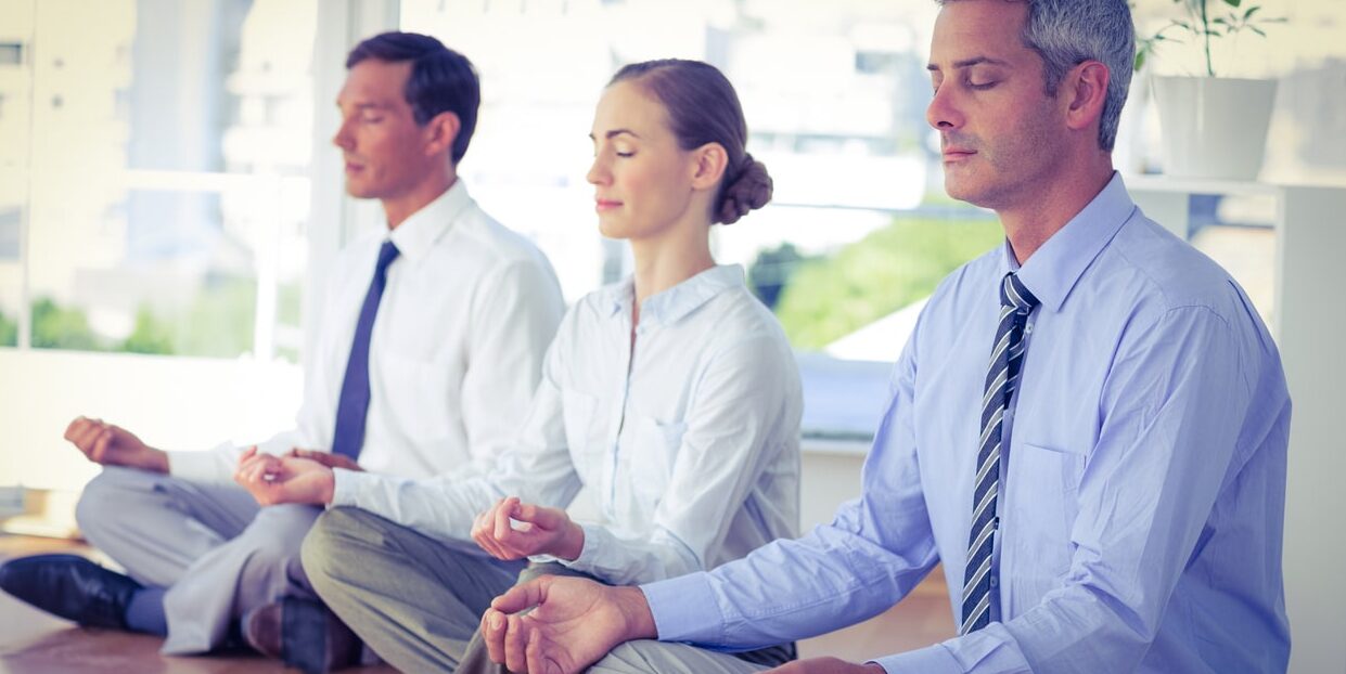 business people doing yoga on floor