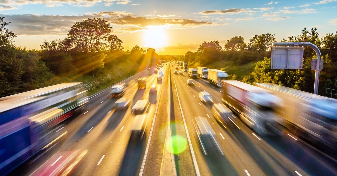 heavy traffic moving at speed on uk motorway in england at sunset