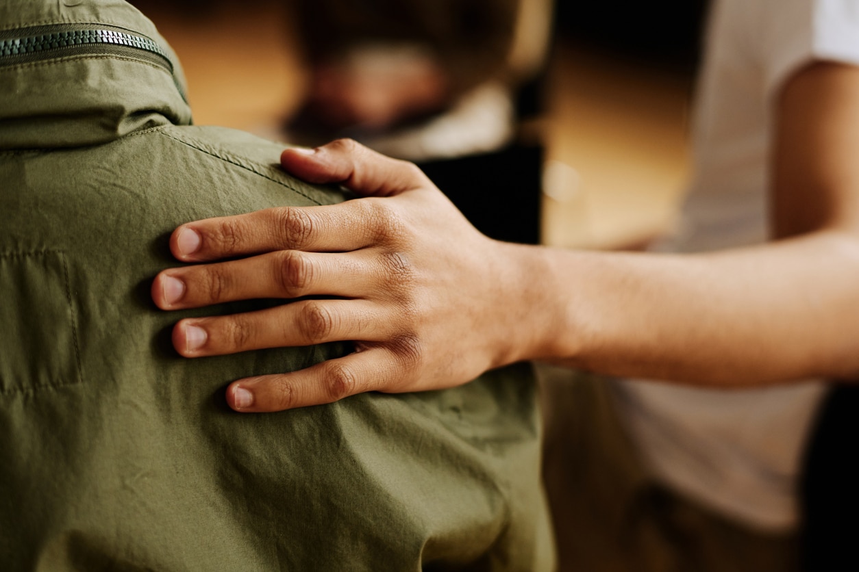 hand of young supportive man consoling his friend with post traumatic syndrome