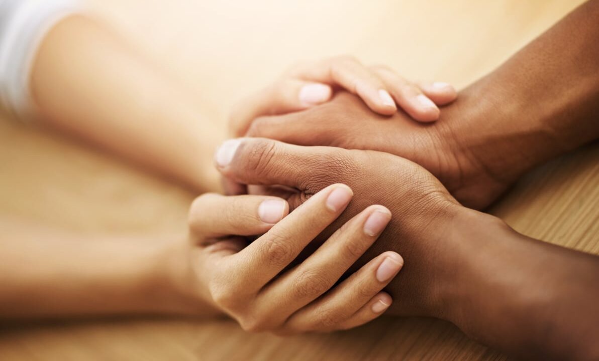empathy, hands and support with friends in home at wooden table together for love or trust. anxiety, depression and mental health with people in apartment from above for community, hope or psychology