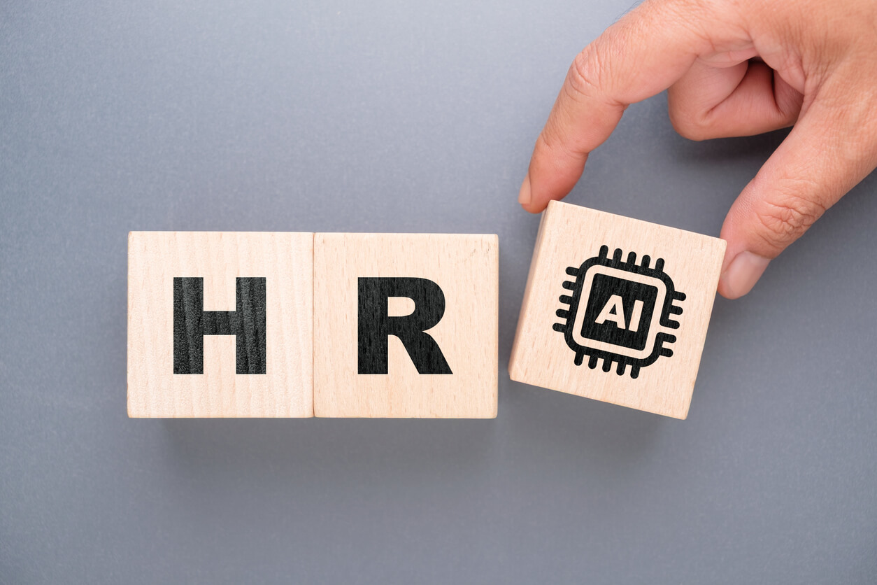 wooden block depicting HR and AI - concept is the use of AI in HR